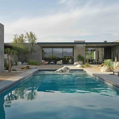Contemporary house with a clear blue pool and a stylish patio, ideal for enjoying sunny days and outdoor gatherings.